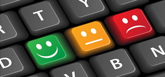 A computer keyboard features three prominent glowing keys with facial expressions: a green happy face, an orange neutral face, and a red sad face.