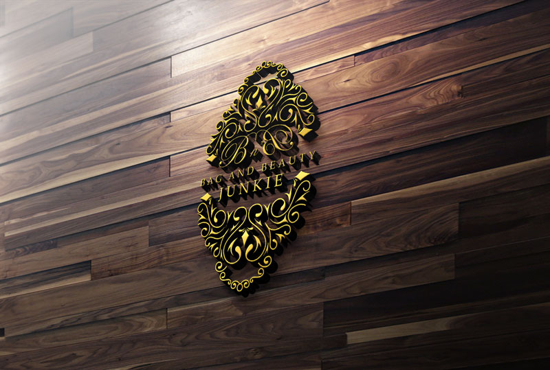A golden, ornate logo reading Bag and Beauty Junkie is centered on a dark wood panel wall.