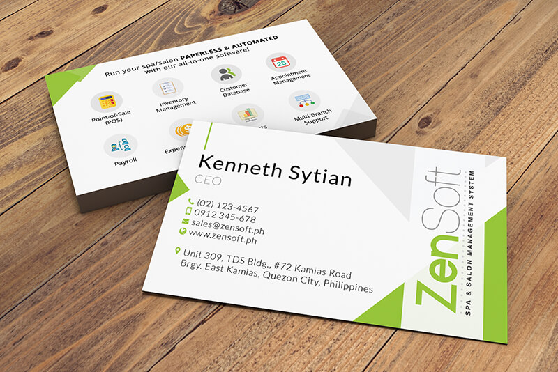 Two stacked ZenSoft business cards for CEO Kenneth Sytian display contact details and software features on a wooden table.