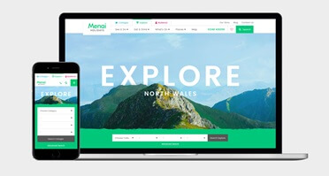 A laptop and a smartphone displaying a responsive travel website for exploring North Wales.