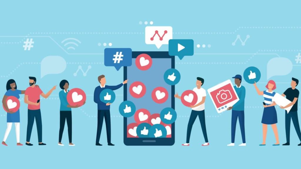 A diverse group of people stand around a giant smartphone surrounded by social media icons like hearts, thumbs up, and hashtags on a light blue background.