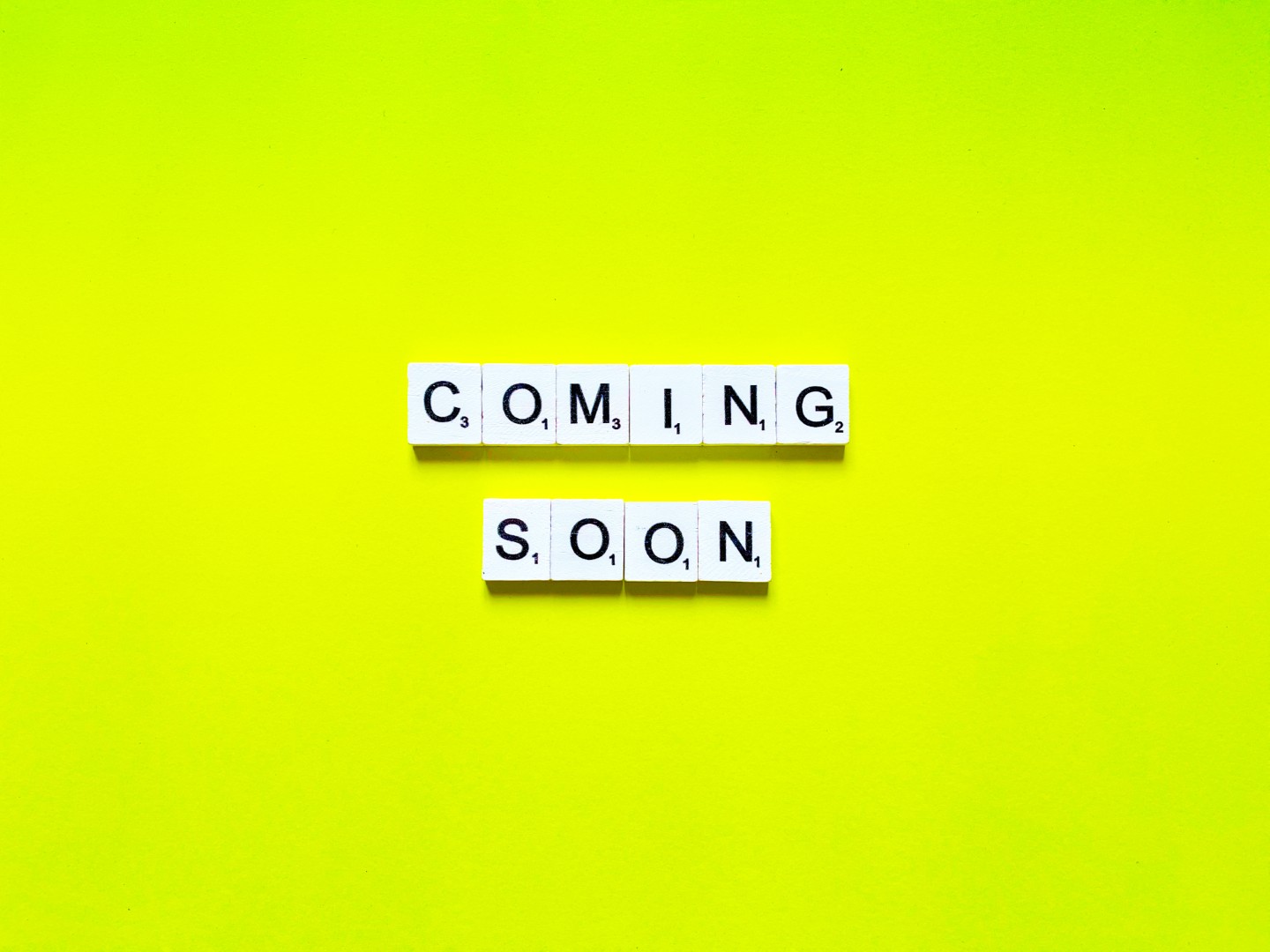 The words COMING SOON spelled out in Scrabble tiles on a bright yellow-green background.