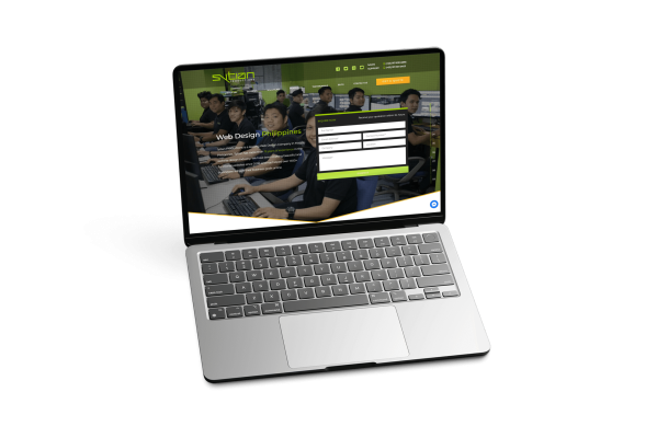 A silver laptop displays a website for Sytian Productions, featuring a contact form and a team photo in the background.
